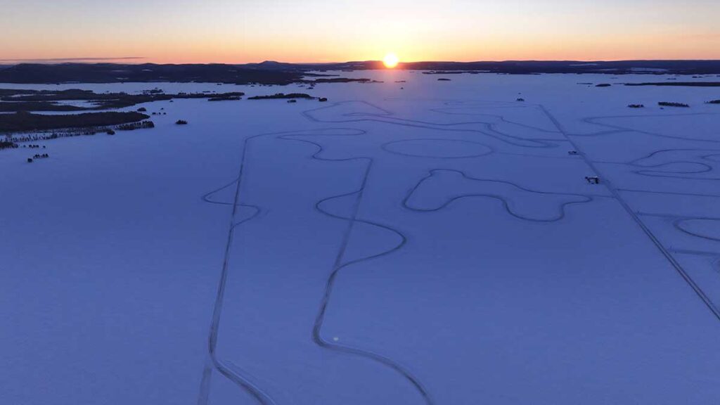 Coucher de soleil sur un tracé enneigé évoquant les expériences de conduite hivernale du Circuit Paul Ricard